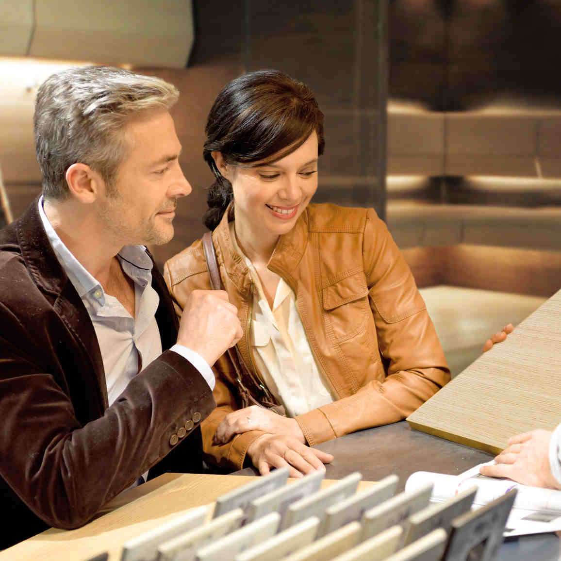 Nainen ja mies valitsemassa paneelin sävyjä pöydän ääressä